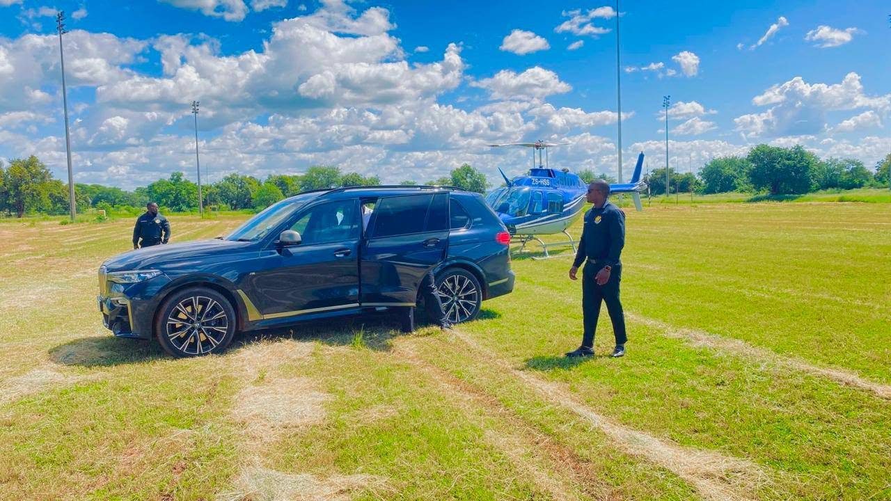 Officers securing a client vehicle beside a waiting helicopter